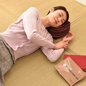 Woman lied down on the Seiza Cushion with two books beside her