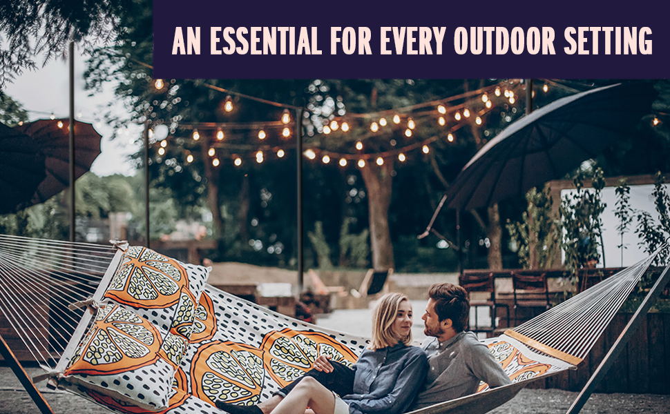 Couple outdoors cuddling in a hammock with outdoor lights