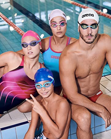 swimmers posing on the side of the pool, each wearing a different swim cap with fun prints