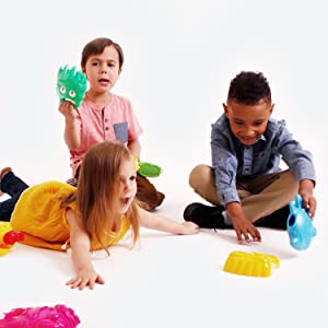 three young diverse and multiethnic kids happily play together with beach sand toys for water