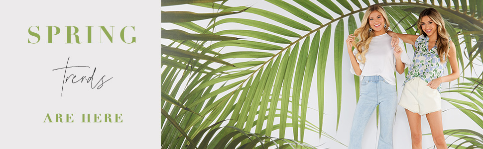 Two women in spring/summer apparel in front of a palm tree background